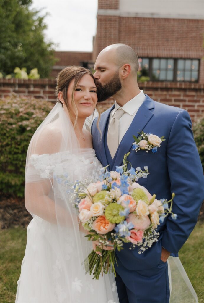 groom kissing the bride on the forehead