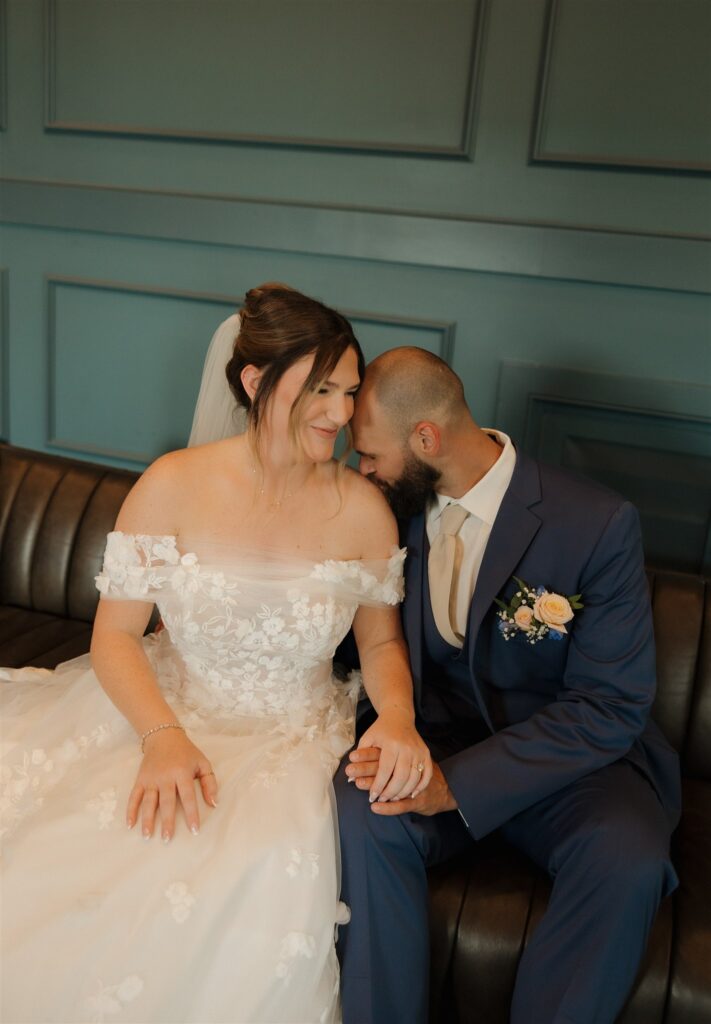 groom kissing the bride on the shoulder 