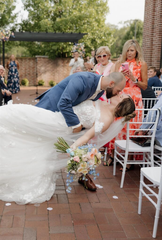 portrait of the newlyweds kissing after the ceremony