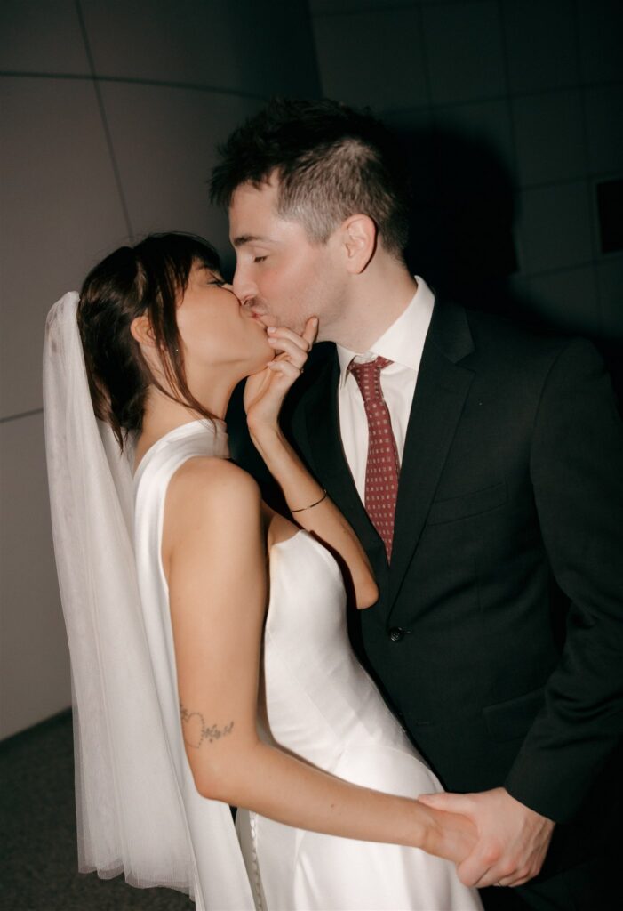 cute portrait of the newly married couple kissing at their wedding reception