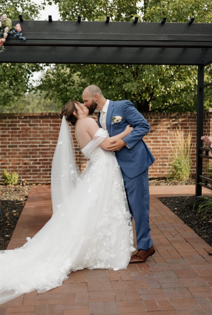 cute picture of the bride and groom kissing after their ceremony