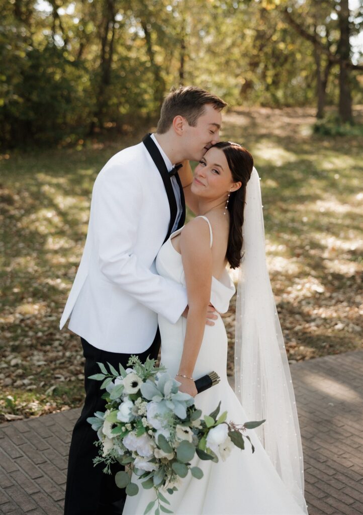 Groom, kissing the bride on the forehead