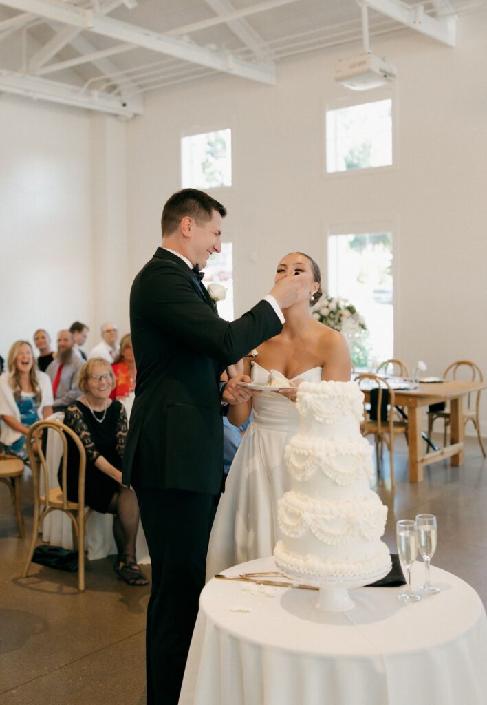 newlyweds trying their wedding cake